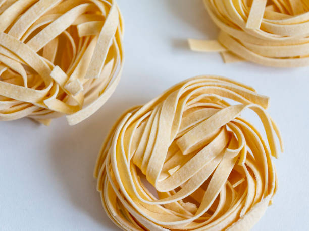 istock Italian unprepared taglitelli pasta on a white background. 1227139666