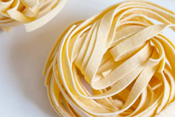 istock Italian unprepared taglitelli pasta on a white background. 1227139683
