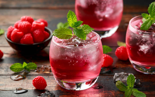 istock Refreshing raspberry cocktail with ice and mint on wooden table 1227139941