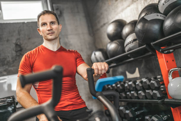 istock Man exercising on bike at gym 1227144823