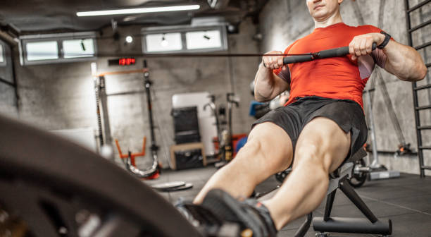 istock Man doing cardio workout on rowing machine in gym 1227146249