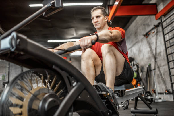 istock Man doing cardio workout on rowing machine in gym 1227146398