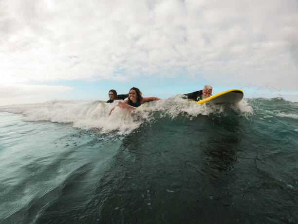 istock Happy multi generation surfers having fun inside ocean riding boards - Young people doing surf during vacation - Travel, youth and extreme sport concept - Focus on woman face 1227146499