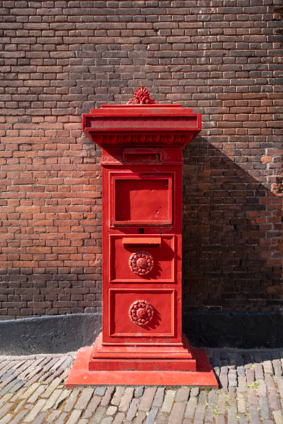 istock red old Dutch mailbox standing against a brick wall 1227147307