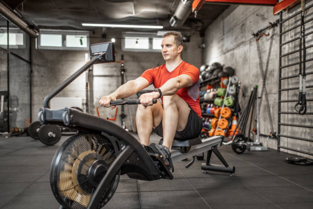 istock Man doing cardio workout on rowing machine in gym 1227147662