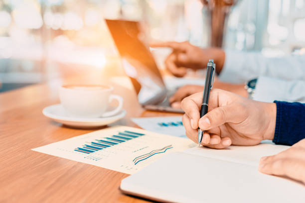 istock Businessman hand writing note on a notebook. Business man working at office desk. 1227147938