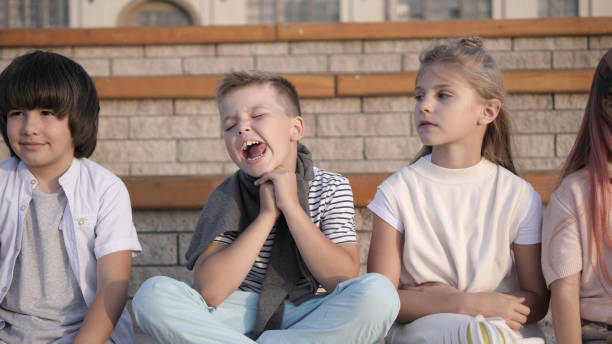 istock Four kids looking bored and overtired seating on a bench 1227148056