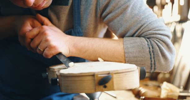 nahaufnahme von professionellen meister handwerker luthier arbeiten an der schaffung von handgemachten violine in einem workshop. - making craftsperson italian music musical instrument stock-fotos und bilder