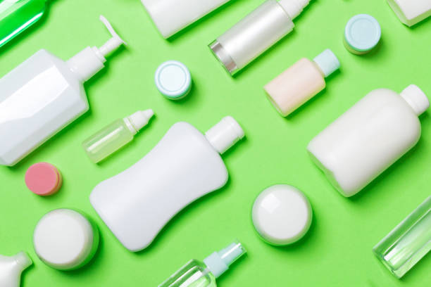 istock Top view of different cosmetic bottles and container for cosmetics on green background. Flat lay composition with copy space 1227149143