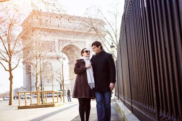 istock a married couple walk through Paris at the arc de Triomphe. 1227149625