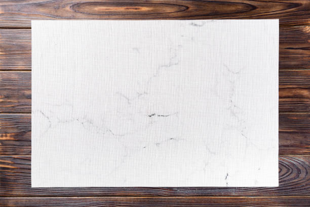 Top view of textile white mat for dinner on wooden background with copy space