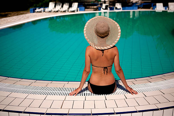 Woman sitting by the swimming pool stock photo
