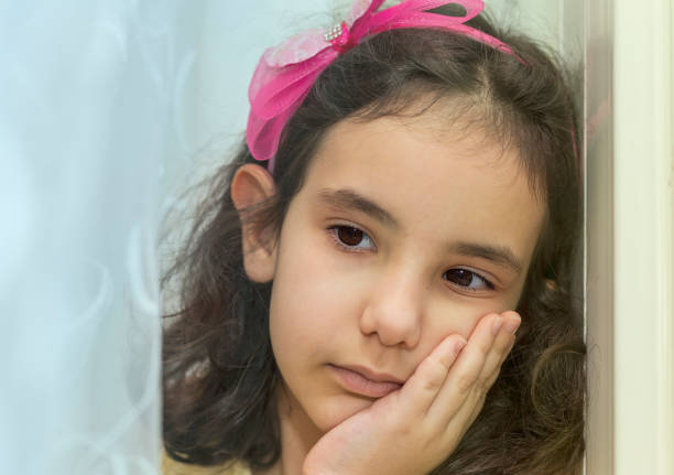istock A little girl boring next the window 1227153314