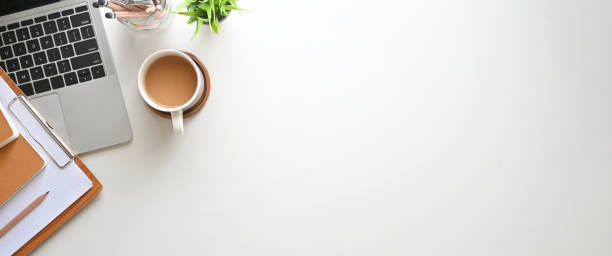 istock Simple Top view table - Creative flat lay office desk. Laptop, notebooks and coffee cup on white background. Panorama banner background with copy space. 1227154544