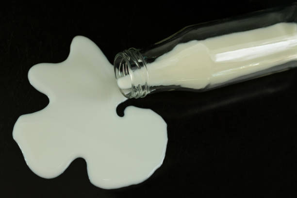 istock Bottle with spilled milk on a black background. Copy space. 1227155544