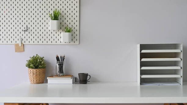 istock Workspace coffee cup that surrounded by document shelf, picture frame, pencils in glass vase, pine cone, notebooks and wild grass in bottle. 1227155745