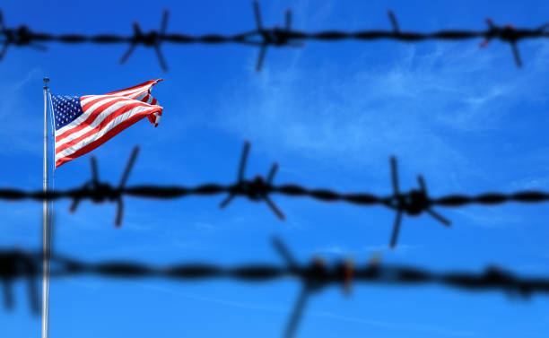 istock American flag and barbed wire fence 1227155869