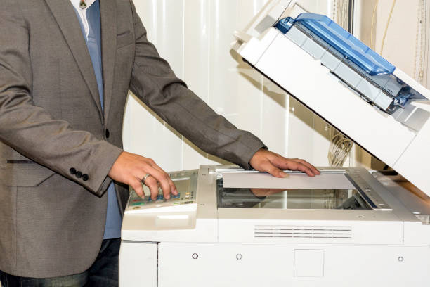 istock Midsection side view of businessman pressing printer's button in office 1227158070