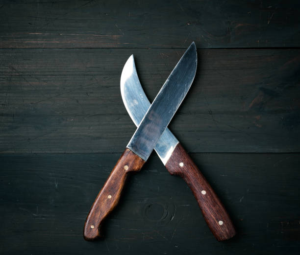 istock two sharp knives lie on a brown wooden surface 1227160719