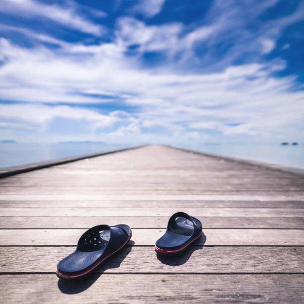 Flip-flops on wooden pier at sunny weather