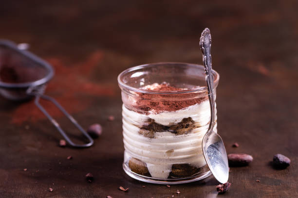 Traditional Italian dessert tiramisu in a glass. Poster copy space concept. Traditional Italian dessert tiramisu in a glass. Poster copy space concept. cake jar stock pictures, royalty-free photos & images