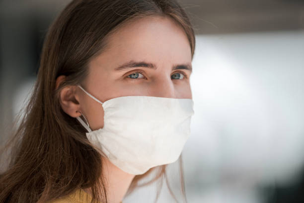 istock young woman in a protective mask looking at you 1227167586