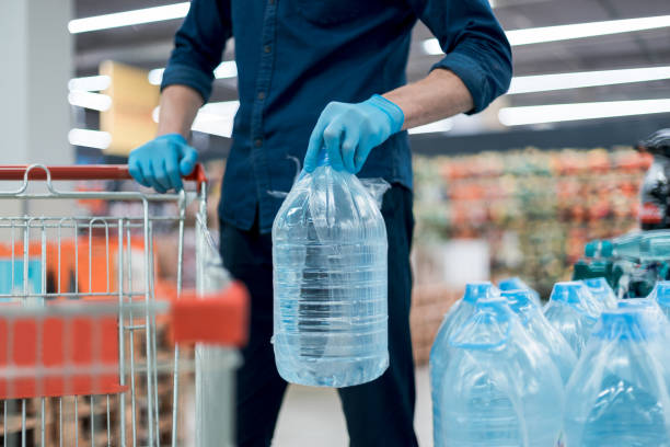 istock man in protective gloves with a bottle of drinking water 1227167734