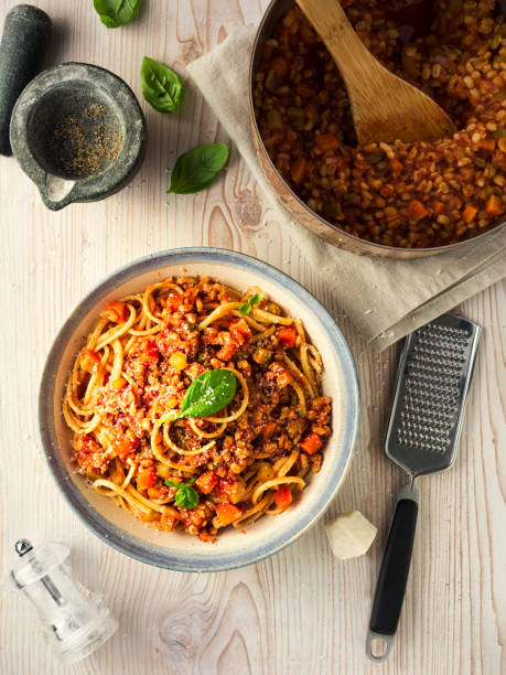 Healthy Vegan spaghetti bolognese Home made freshness vegan bolognese made by barley,red lentils with tomato basil sauce,carrot,celery with spaghetti and shaved hard coconut cream bolognese sauce photos stock pictures, royalty-free photos & images