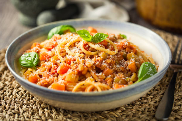 Healthy Vegan spaghetti bolognese Home made freshness vegan bolognese made by barley,red lentils with tomato basil sauce,carrot,celery with spaghetti and shaved hard coconut cream bolognese sauce photos stock pictures, royalty-free photos & images