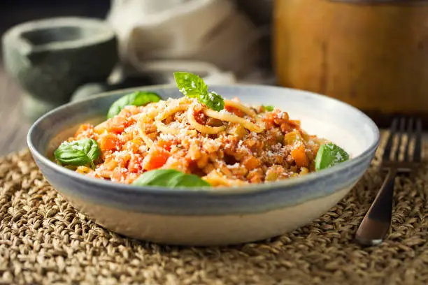 Home made freshness vegan bolognese made by barley,red lentils with tomato basil sauce,carrot,celery with spaghetti and shaved hard coconut cream