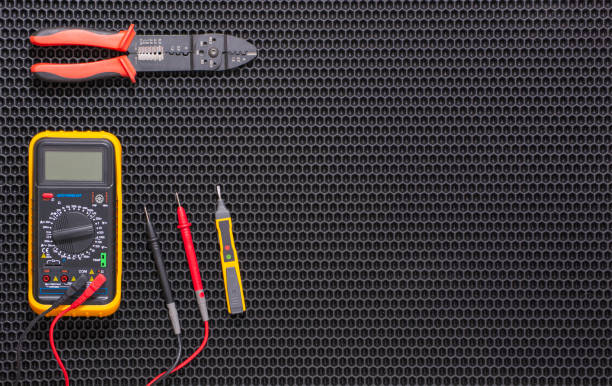 multimeter, indicator screwdriver and wire stripper on a black rubber mat - meter electric meter electricity fuel and power generation imagens e fotografias de stock