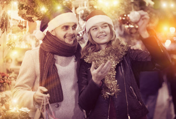 istock Girl with boy in Christmas hat choosing decorations 1227174892