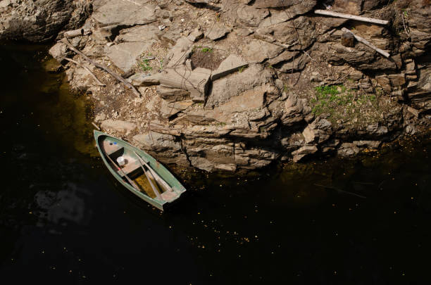 istock Small boat on lake near rocky shore 1227174965