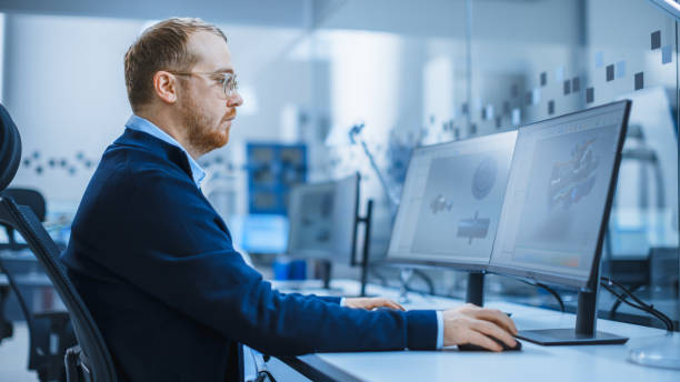 istock Shot of a Heavy Industry Engineer Working on Personal Computer, Screen Shows CAD Software Showing New Generation Electric Engine. Industrial Factory with High-Tech CNC Machinery 1227179614