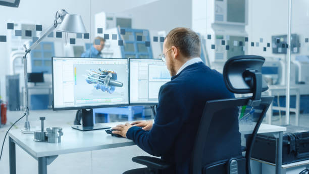 istock Industrial Engineer Working on a Personal Computer, Two Monitor Screens Show CAD Software with 3D Prototype of Hybrid Electric Engine and Charts. Working Modern Factory. 1227180018