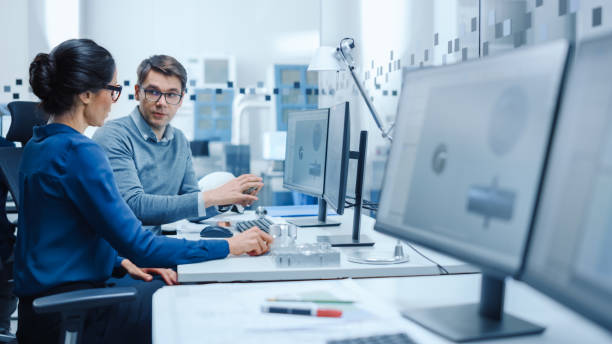 istock Modern Factory: Male Industrial Engineer Explains to Female Project Supervisor Functions of the Machine Part Comparing it to one on Computer Screen. They use CAD Software for Design, Development 1227182302
