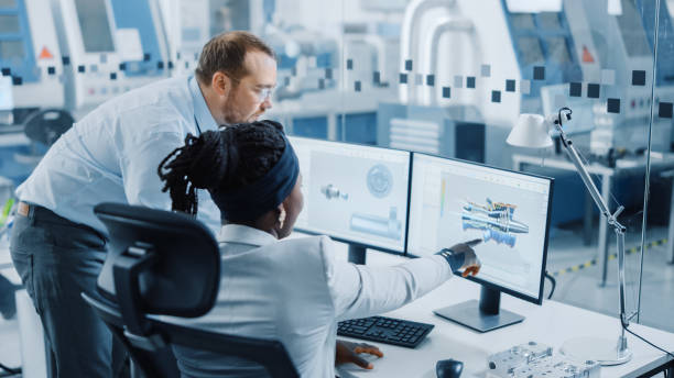 istock Modern Factory: Male Project Supervisor Talks to a Female Industrial Engineer who Works on Computer. They use CAD Software for Design Zero-Emissions Engine. Working High-Tech Industrial Facility 1227182407