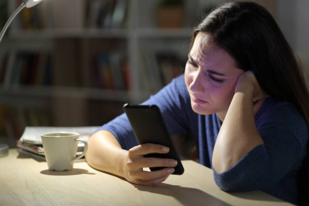 istock Sad woman complaining checking phone at night at home 1227182621