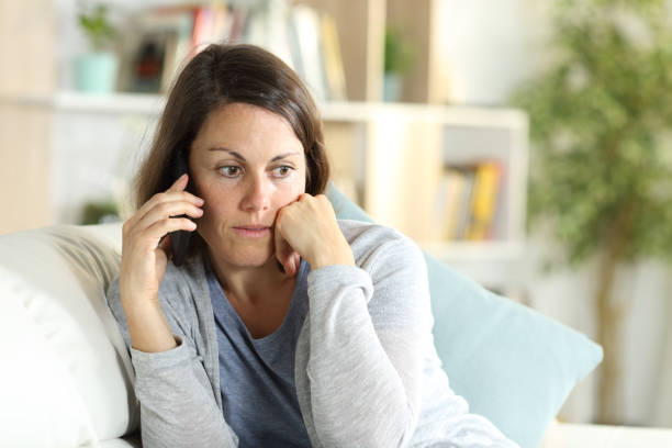 istock Pensive middle age woman calling on phone at home 1227182859