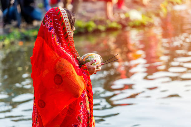 Devotee offering prayers to God During Chhath Puja Festival Kathmandu,Nepal - November 1,2019: Hindu devotee offering prayers to sun god standing in water according to hindu rituals during Chhath Puja Festival in Kathmandu. Chath Puja rituals ghat photos stock pictures, royalty-free photos & images