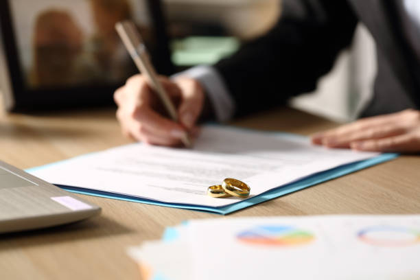 freelance hands signs divorce papers at night - divorce imagens e fotografias de stock