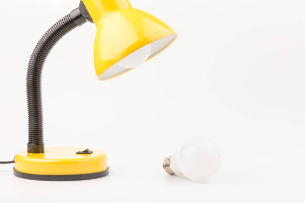 Yellow desk lamp isolated on white background. The concept of day and night