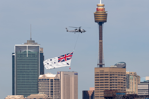 Sydney, Australia - October 5, 2013: Royal Australian Navy (RAN) Sikorsky S-70B-2 Seahawk Helicopter N24-001 flying the White Ensign of the RAN over Sydney Harbour.