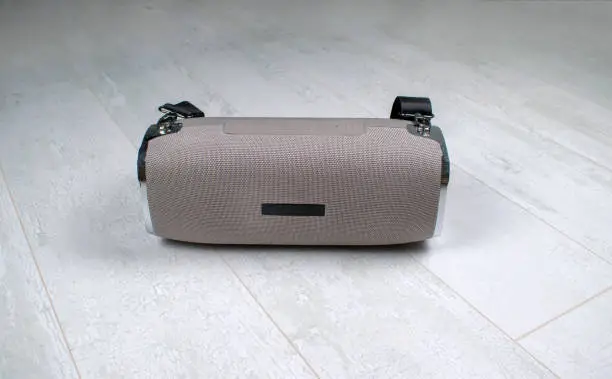 Portable grey speaker with the removable soft handle. Connect with smartphone or pc to play the music. Close up,