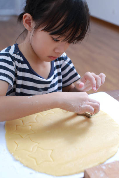 istock Little girl making cookies 1227192270