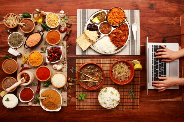Working Lunch Working at home due to Virus Pandemic and surrounded with Indian and Asian Cuisine Dishes with Herbs and Spices for a healthy lifestyle and eating carbohydrate food type photos stock pictures, royalty-free photos & images