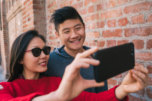 istock Asian couple taking a selfie with mobile phone. 1227193933