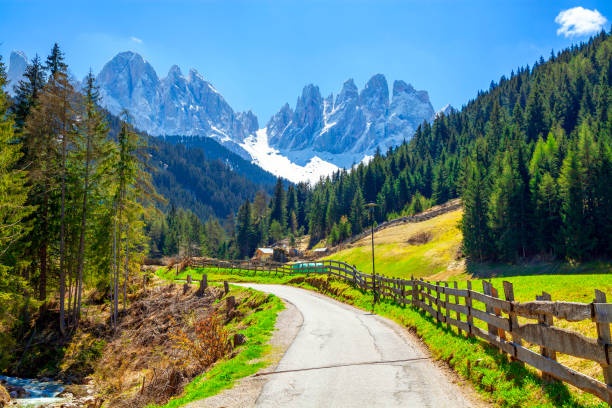 イタリア、ドロミテのサンタ・マッダレーナ村の美しい景色を望むアルパイン道路。 - country road fence road dolomites ストックフォトと画像