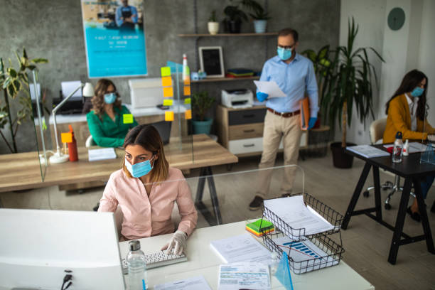 istock Colleagues with protective face masks working in bank office 1227194056