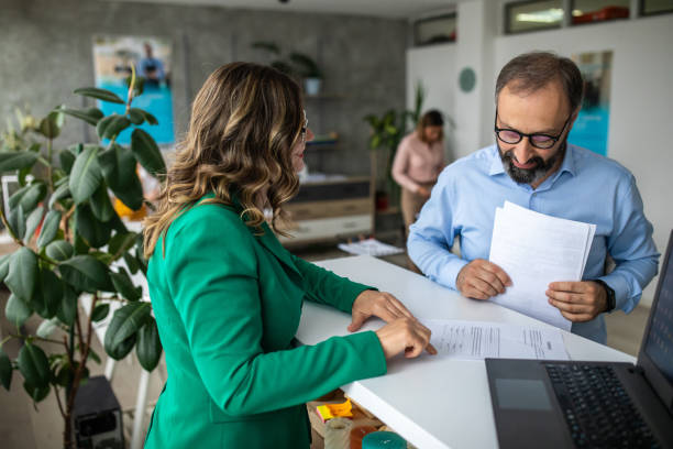 empresario hablando con asesor financiero en banco - mostrador en el banco fotografías e imágenes de stock